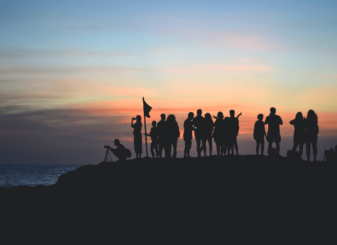 United team standing on mountain at sunset