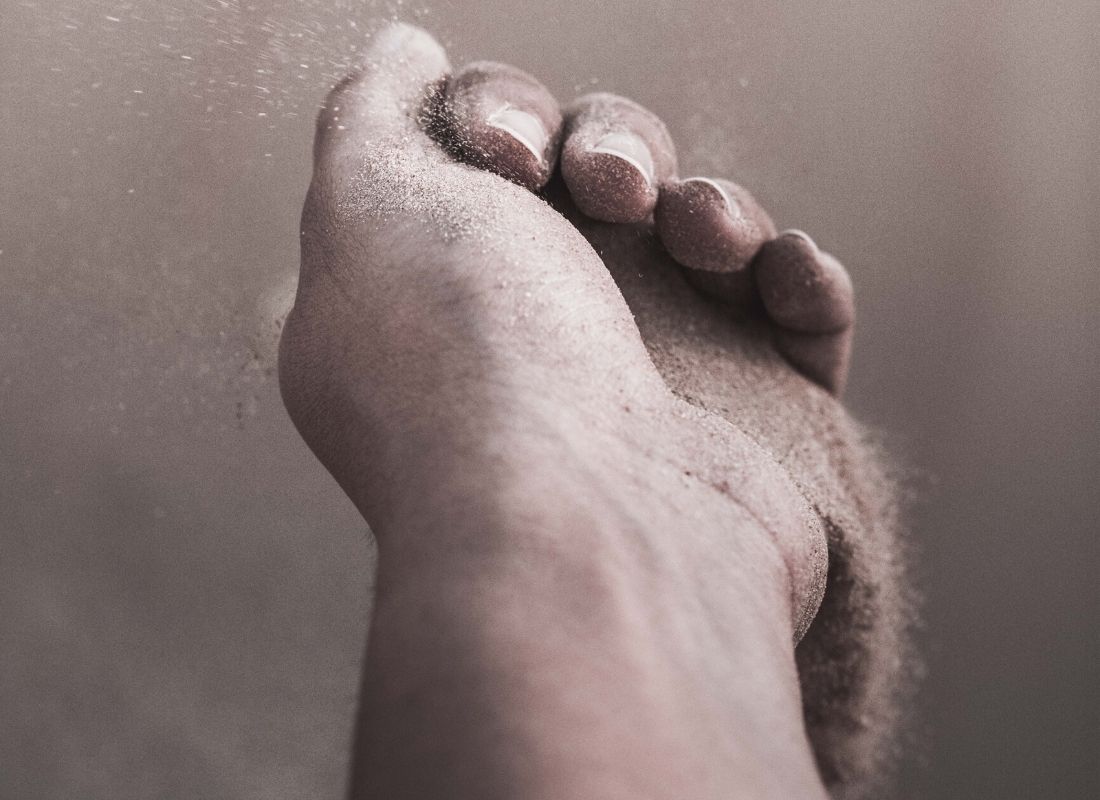 Sand slipping out of person's hand