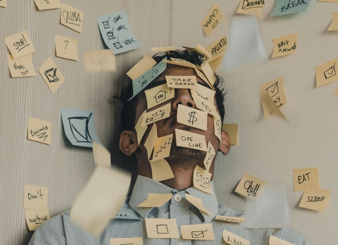 stressed man in corner with sticky notes on face