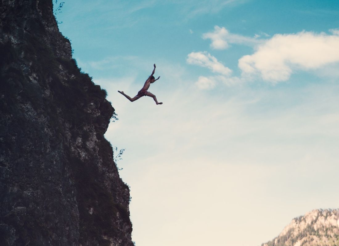 man jumping off cliff to conquer fears