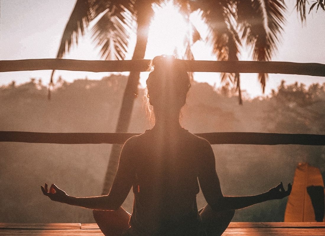 Woman sitting and visualizing her future in meditation at sunset