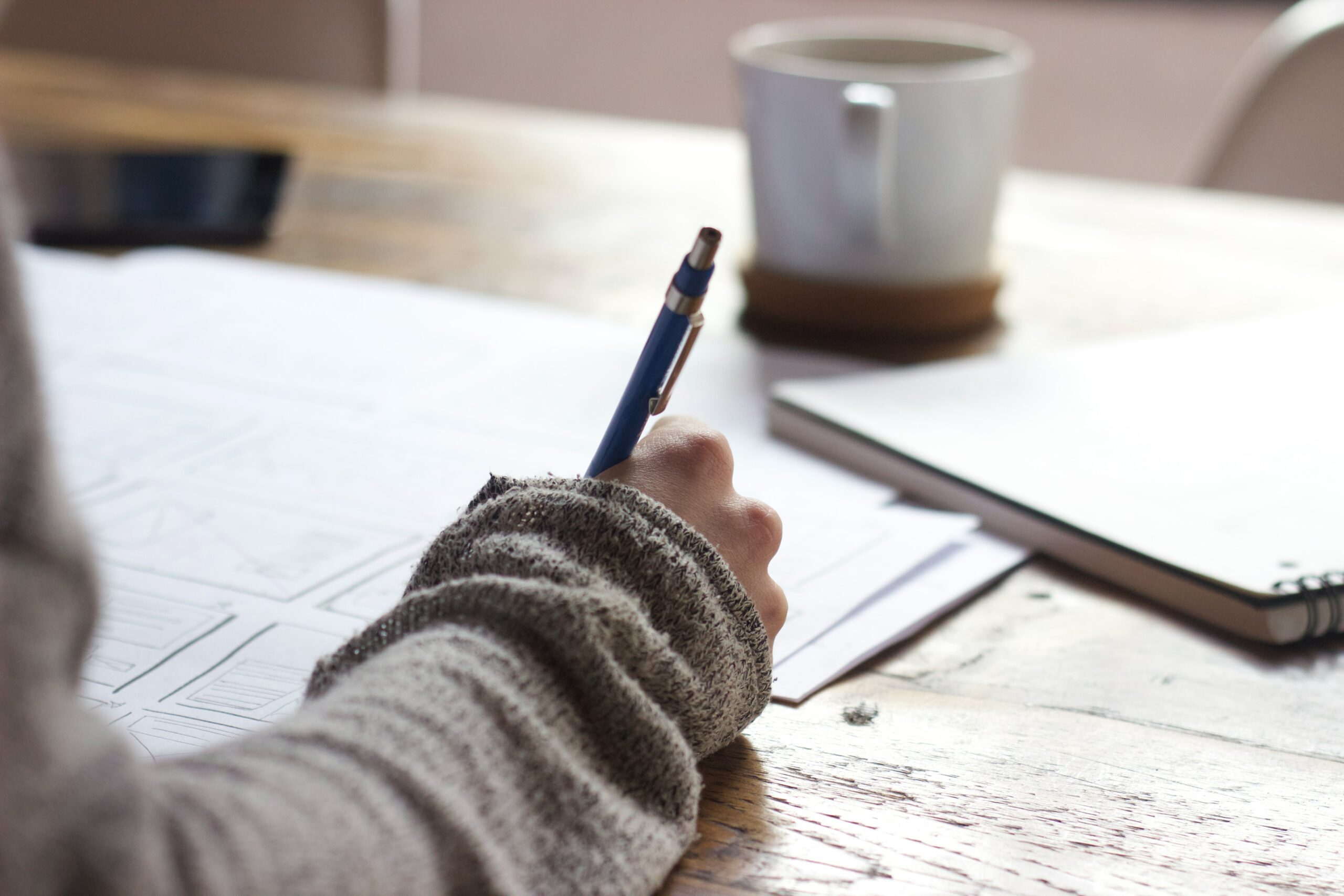 Image of person's hand writing in a notebook